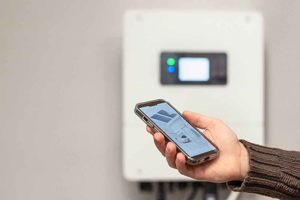 Smartphone mit Energieflussanzeige vor einem Stromspeicher
