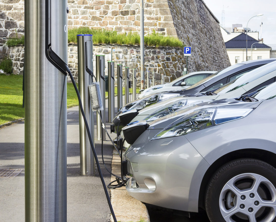 Mehrere Elektrofahrzeuge an einzelnen Ladepunkten auf einem gemeinsamen Parkplatz